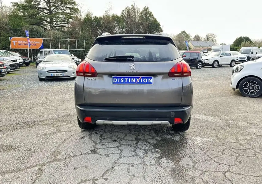 Vue arrière d’un Peugeot 2008 Crossway gris foncé avec badges latéraux et caméra de recul visible en extérieur.