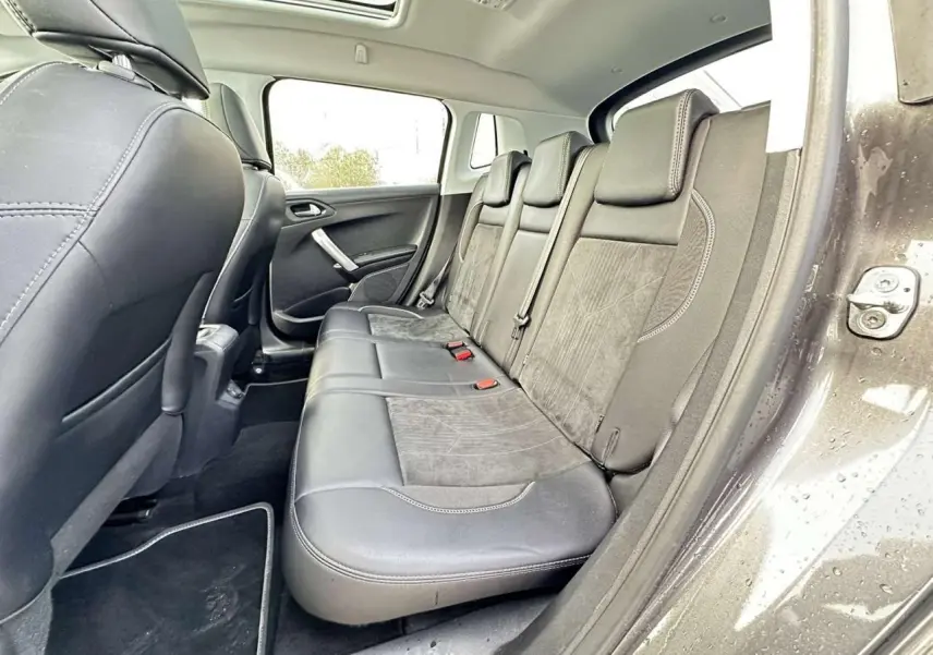 Vue intérieure côté droit sur la banquette arrière en cuir et alcantara du Peugeot 2008 gris foncé avec toit panoramique.