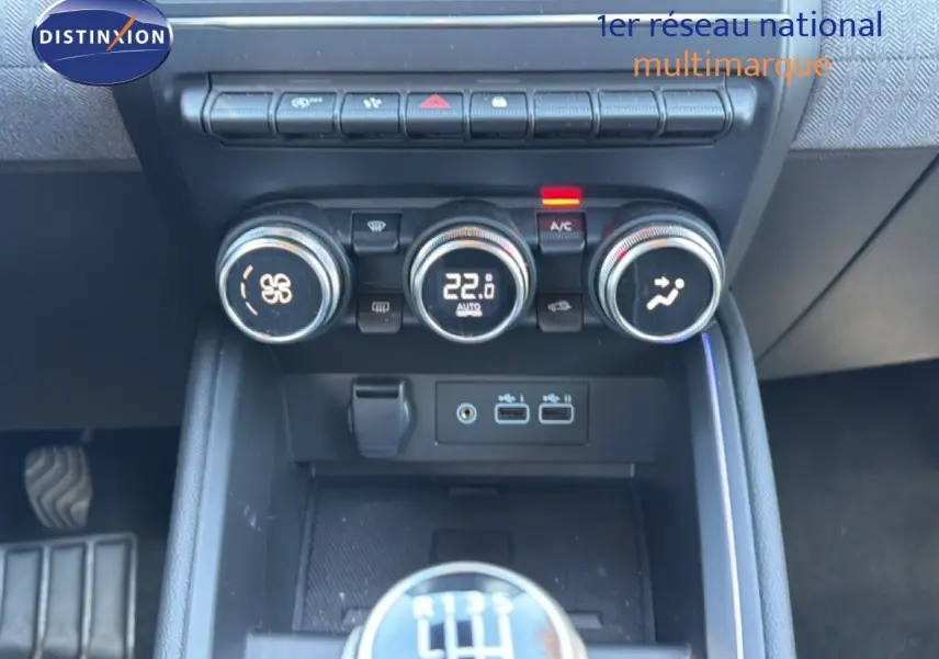 Gros plan sur la console centrale de la Renault Clio 2025, montrant les commandes de climatisation et le levier de vitesse manuel.