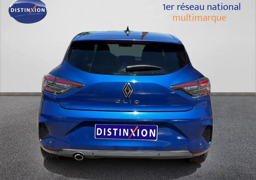 Vue arrière d'une Renault Clio 2025 bleu iron metal avec feux arrière LED et sortie d'échappement visible côté gauche.