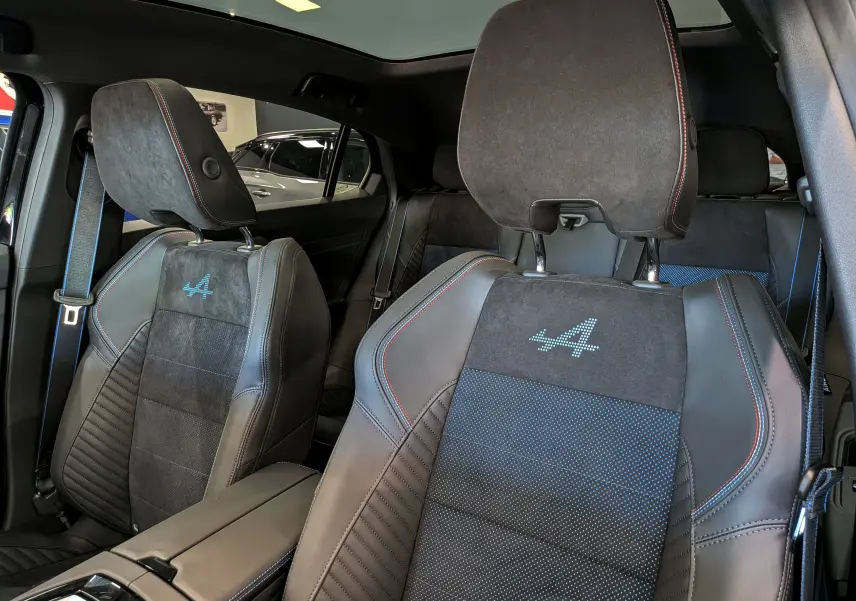 Vue intérieure rapprochée des sièges avant en cuir noir et alcantara avec logo Alpine brodé sur Renault Rafale 2026.