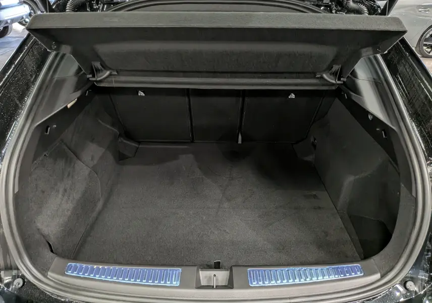 Coffre ouvert vu de l'arrière d'une Renault Rafale noir étoilé, intérieur spacieux et tapis noir.