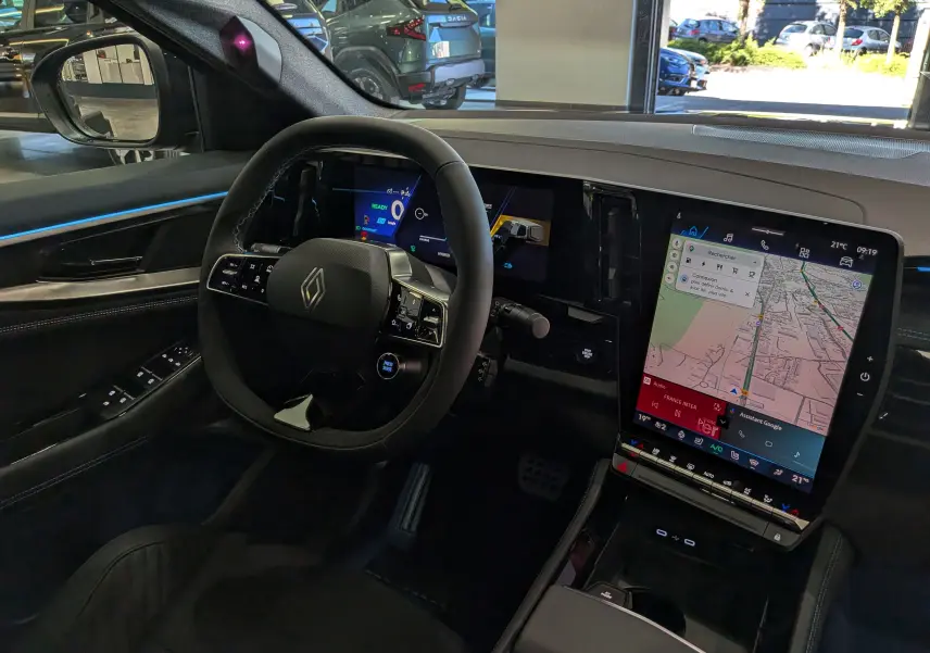 Vue intérieure côté conducteur du Renault Rafale 2026, tableau de bord numérique et écran tactile vertical avec navigation.