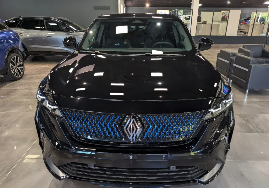 Vue avant d'un Renault Rafale noir étoilé avec calandre à motif bleu et logo central distinctif, en showroom.