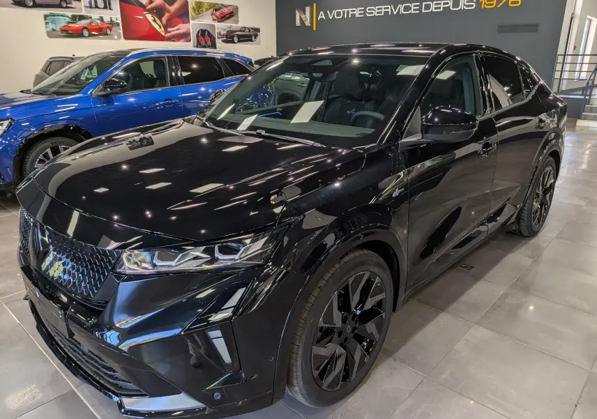 Vue 3/4 avant droite du Renault Rafale noir étoilé, soulignant ses jantes noires et son design sportif intérieur showroom.