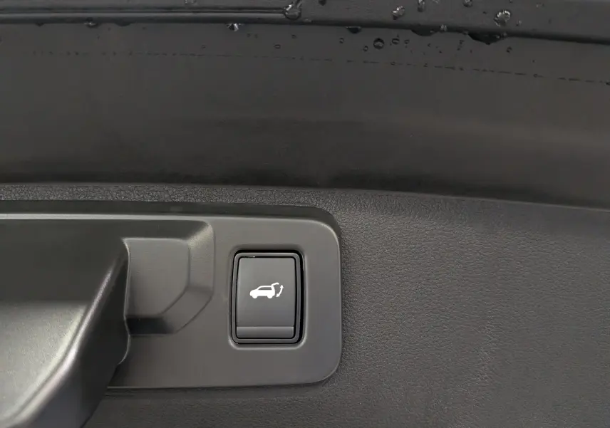 Bouton d'ouverture électrique du coffre sur panneau intérieur noir d'une Renault Rafale Hyper Hybrid 2026.