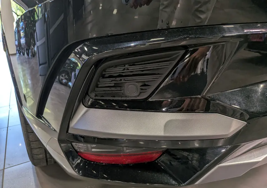 Gros plan sur le pare-chocs avant droit noir étoilé du Renault Rafale 2026, avec détails de la grille et feu antibrouillard.
