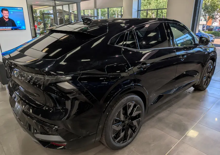 Vue 3/4 arrière droite du Renault Rafale noir étoilé, soulignant ses jantes noires et son design sportif en showroom.