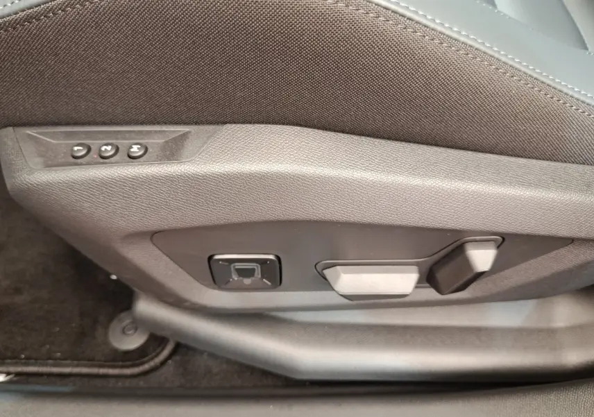 Gros plan sur les commandes de réglage électrique du siège avant droit du Citroën C5 Hybride vert 2026.