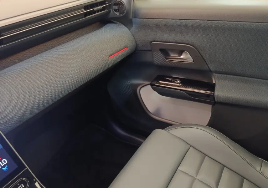 Vue intérieure côté passager avant du Citroën C5 Hybride 2026, avec sellerie grise et détails noirs texturés.