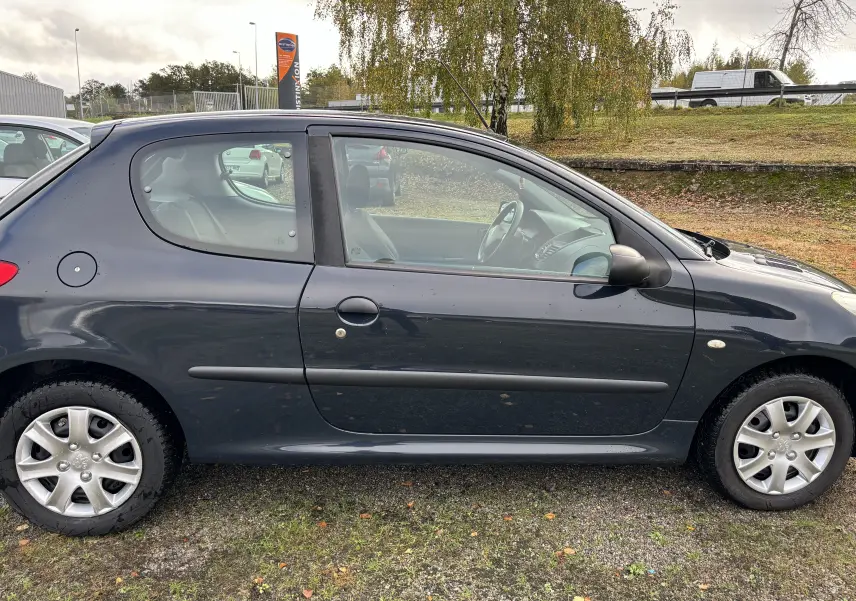 Profil côté gauche d'une Peugeot 206+ gris foncé de 2009, compacte avec portières deux portes et jantes en alliage.