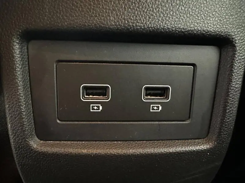 Gros plan sur deux ports USB de recharge situés à l'intérieur du Dacia Duster 2024, finition Extreme blanc glacier.