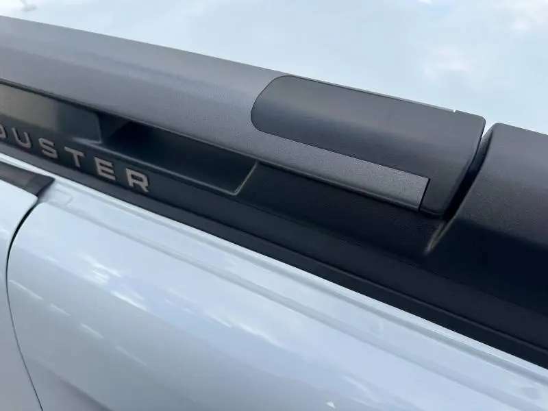 Détail du toit avec barre de toit noire et inscription DUSTER sur un Dacia Duster blanc glacier 2024.