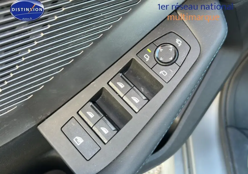 Gros plan sur les commandes des vitres et rétroviseurs côté gauche d'une BMW Série 1 F40 gris Skyscraper.