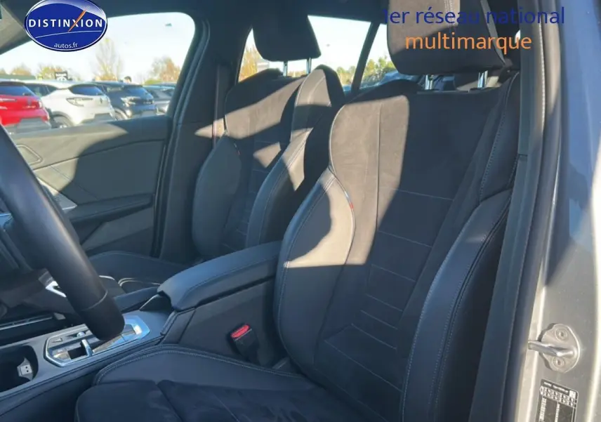 Vue intérieure côté droit sur les sièges avant sport en tissu alcantara noir avec surpiqûres bleues d'une BMW Série 1 gris Skyscraper.