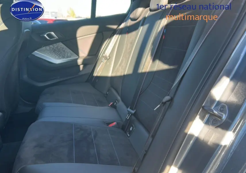 Vue intérieure côté droit des sièges arrière en tissu alcantara noir avec coutures bleues d'une BMW Série 1 gris Skyscraper.