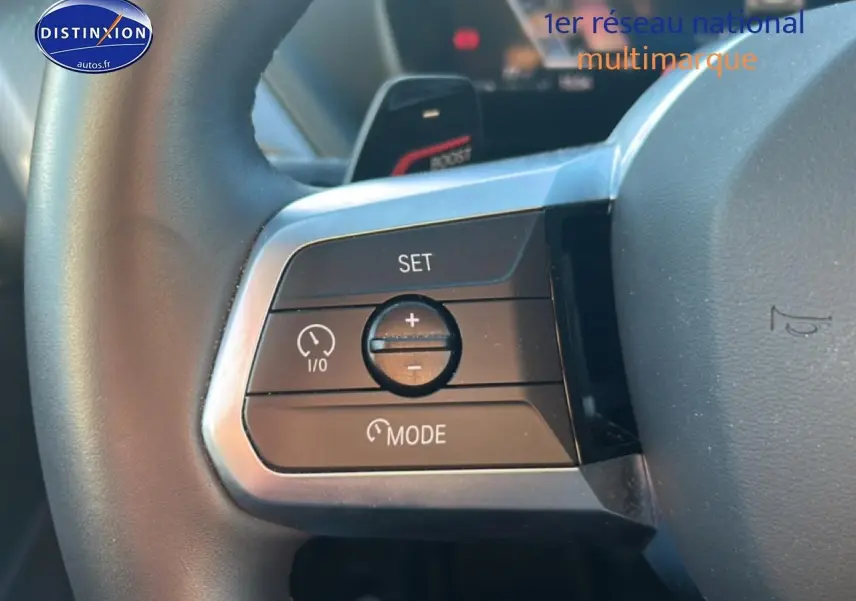 Gros plan sur les commandes de régulateur de vitesse au volant d’une BMW Série 1 gris Skyscraper, version M Sport Pro.