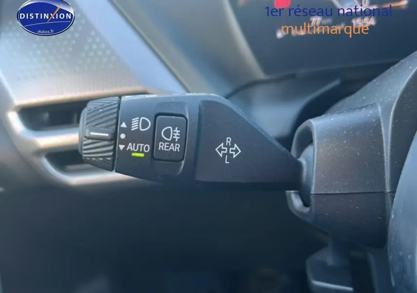 Gros plan sur la commande de phares et clignotants à gauche du volant dans l’habitacle d’une BMW Série 1 gris Skyscraper.