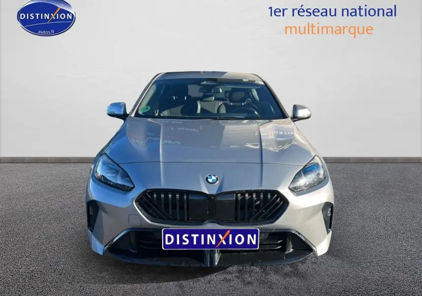 Vue frontale d'une BMW Série 1 118da gris Skyscraper avec calandre noire et phares LED allumés.