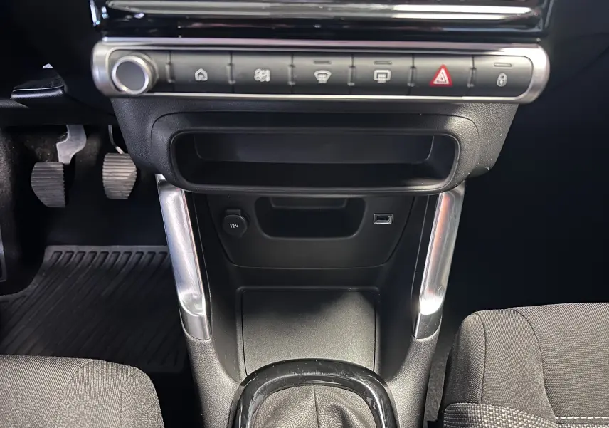 Vue rapprochée de la console centrale et levier de vitesse manuel, avec sellerie tissu gris dans une Citroën C3 Aircross 2024.