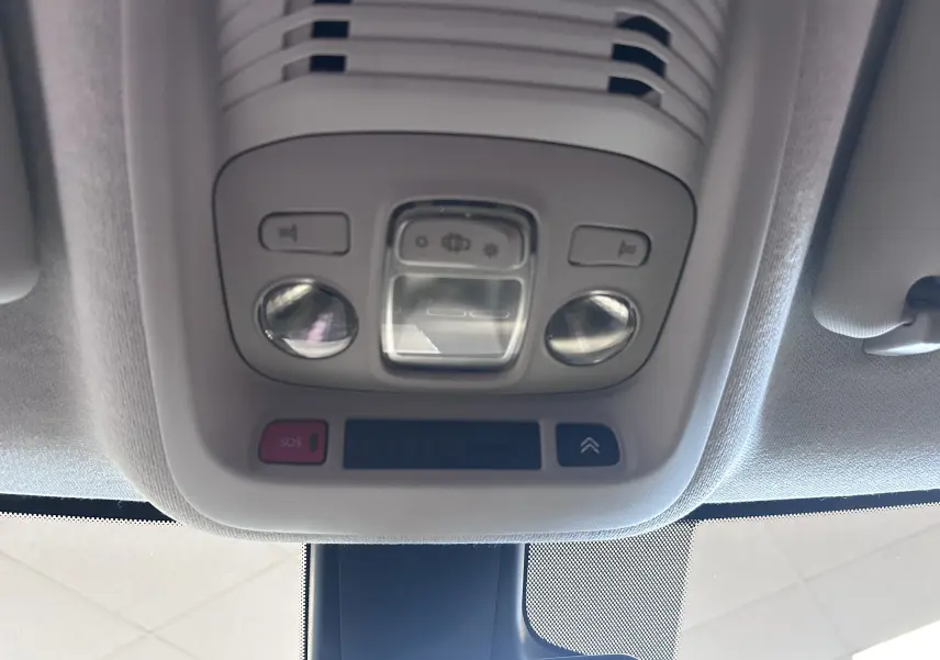 Vue en gros plan du plafonnier intérieur gris clair avec boutons de commande et éclairage du Citroën C3 Aircross 2024.