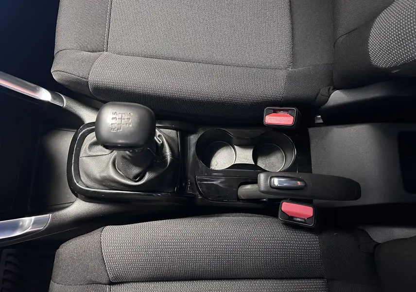 Vue plongeante sur la console centrale du Citroën C3 Aircross 2024, montrant levier de vitesse manuel et sièges tissu gris.