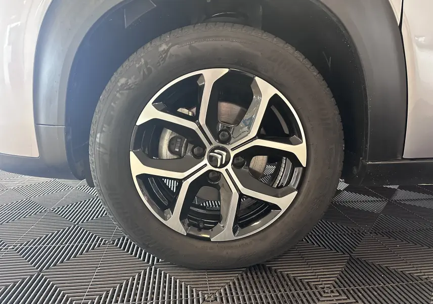 Gros plan sur la jante alliage 16 pouces noire et argentée du côté avant droit du Citroën C3 Aircross gris Artense.
