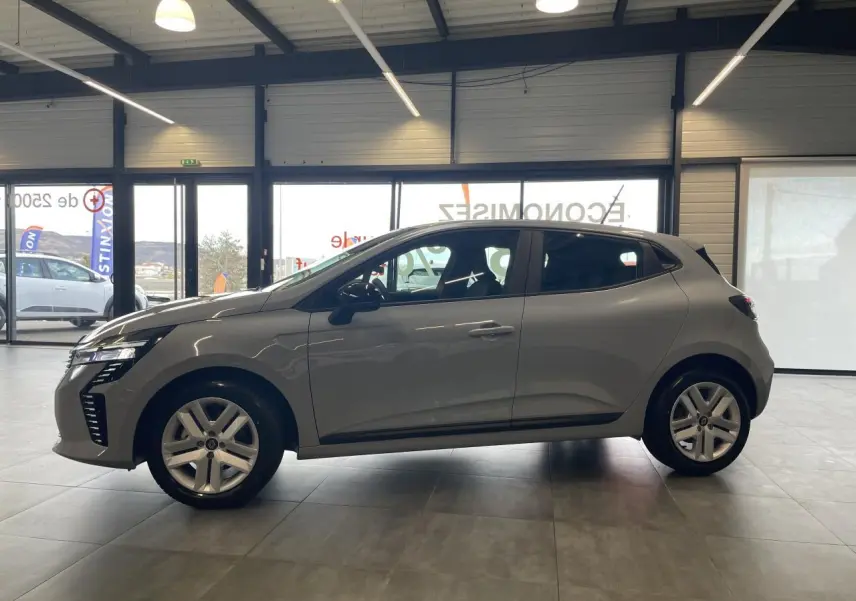 Profil côté gauche d'une Renault Clio 1.5 Blue dCi 2025 gris Rafale en showroom avec jantes alliage et poignées couleur carrosserie.