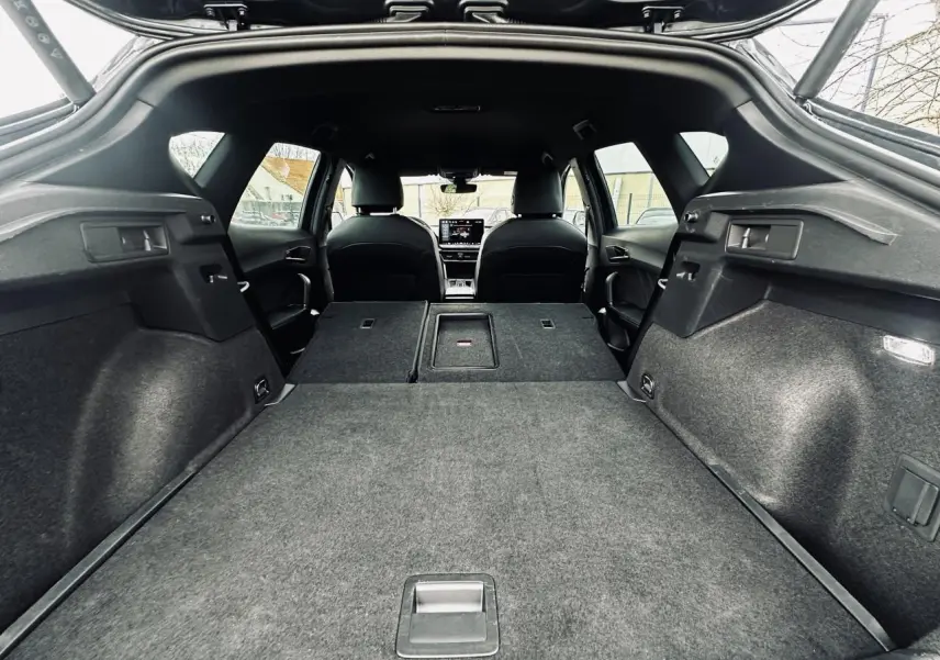 Coffre ouvert vu de l’arrière d’un CUPRA Formentor gris 2025 avec banquette arrière rabattue et intérieur noir.