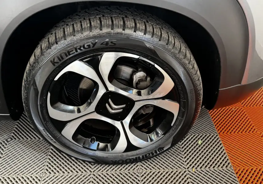 Gros plan sur la roue avant droite gris foncé de la Citroën C3 avec jante alliage bicolore et logo Citroën central.