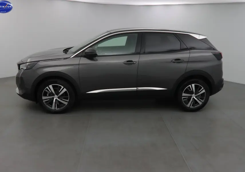 Profil côté gauche d'un Peugeot 3008 gris platinium métal 2023 avec jantes alliage bicolores et toit noir contrasté.