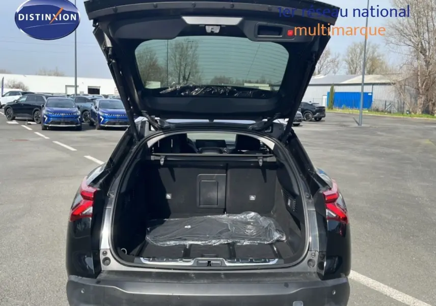 Vue arrière ouverte du coffre d'une Citroën C5 X noire métal 2023, soulignant son espace de chargement généreux.