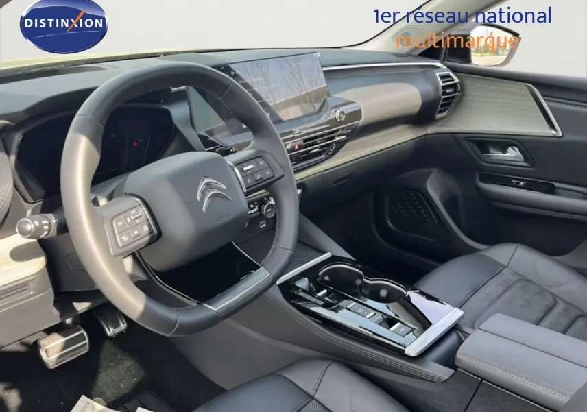 Vue intérieure côté conducteur du Citroën C5 X 2023, tableau de bord moderne avec écran tactile et sellerie cuir noire.