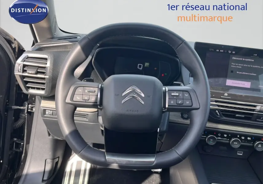 Vue intérieure centrée sur le volant noir du Citroën C5 X 2023 avec tableau de bord et écran tactile visibles.