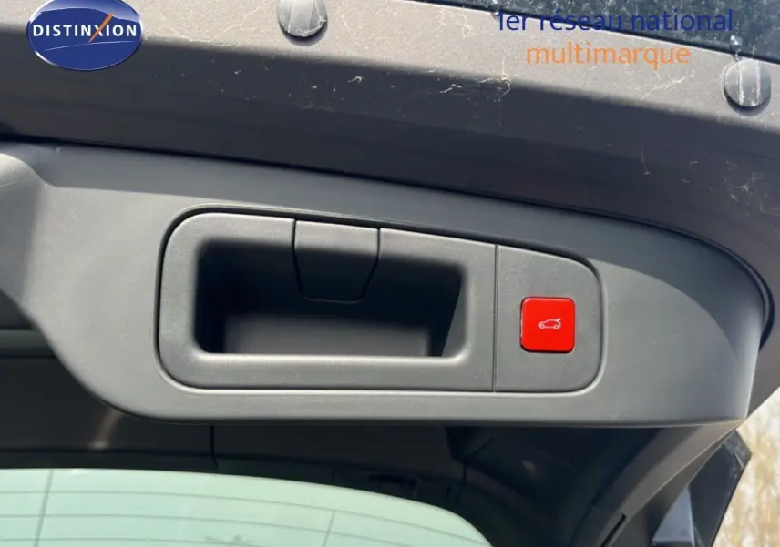 Détail de la poignée intérieure et bouton rouge d'ouverture du coffre sur le hayon d'une Citroën C5 X noir métal.