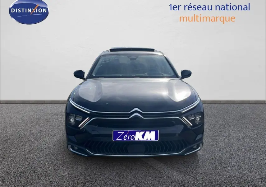 Vue avant d'une Citroën C5 X noire métal 2023 avec signature lumineuse distinctive et calandre moderne.