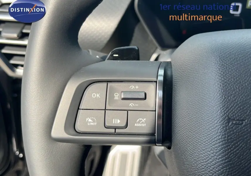 Gros plan sur les commandes au volant du Citroën C5 X 2023, finition noire, avec boutons de régulateur et assistant de conduite.