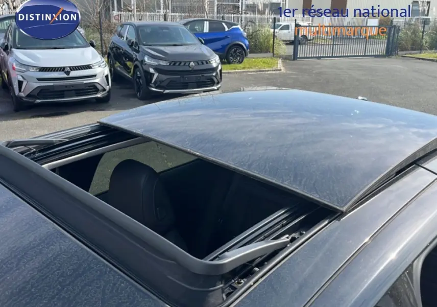 Toit ouvrant ouvert en vue plongeante sur le toit noir métal de la Citroën C5 X 2023, intérieur partiellement visible.