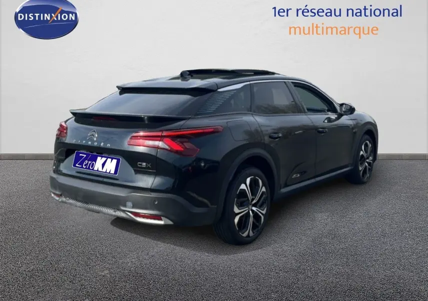 Vue 3/4 arrière droite d'une Citroën C5 X noire métal 2023 avec toit panoramique et jantes bi-ton.