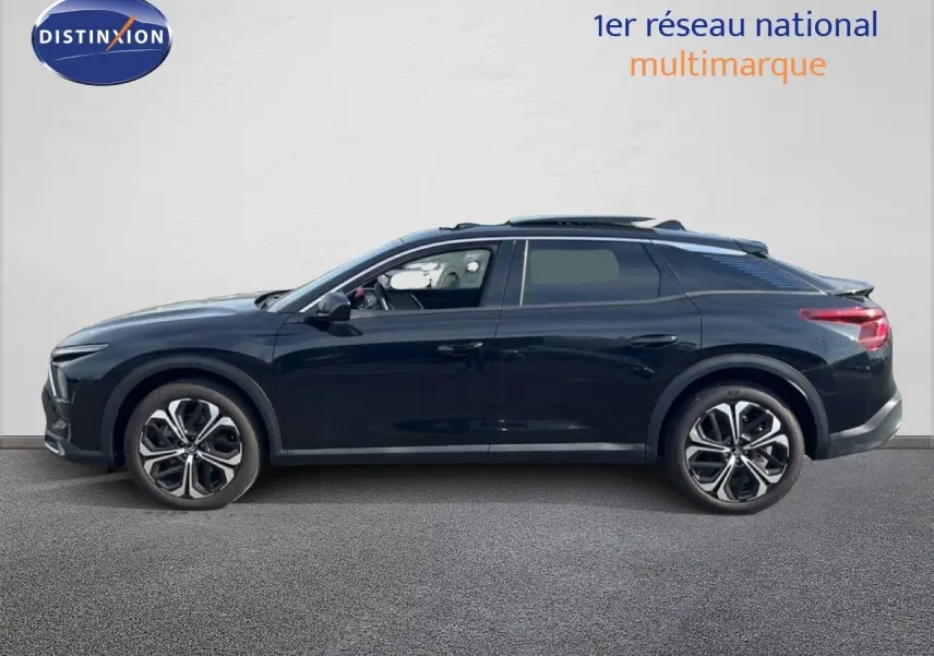 Profil droit d'une Citroën C5 X noire métal 2023, avec jantes bi-ton et toit panoramique ouvert.