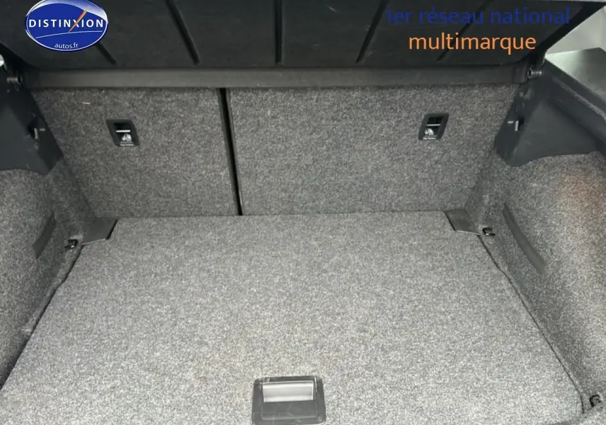 Coffre ouvert d'un SEAT Arona noir minuit, montrant l'espace de rangement avec revêtement gris.