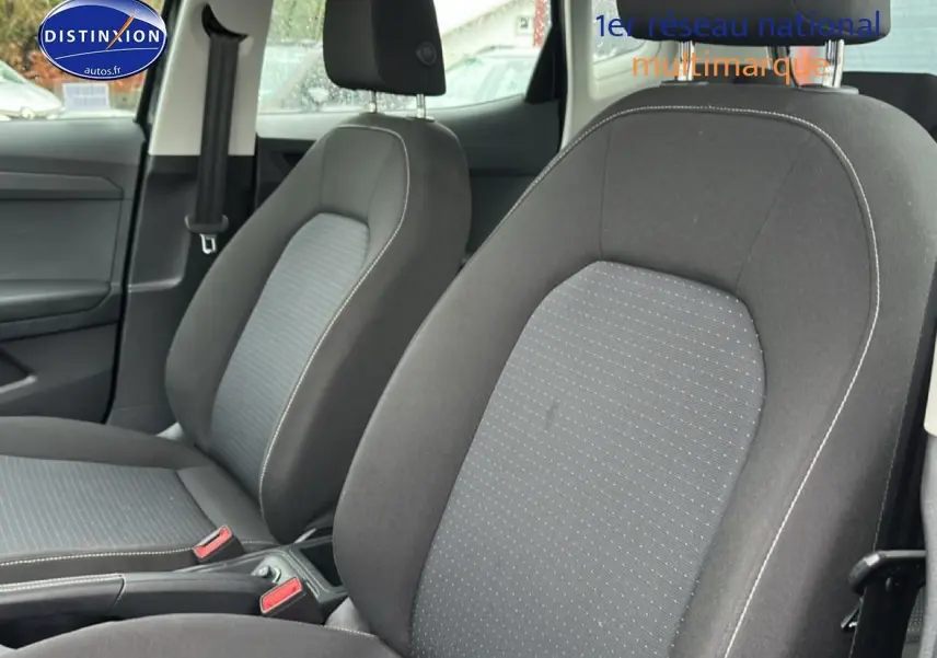 Gros plan sur les sièges avant en tissu gris de la SEAT Arona 2025, vue intérieure côté conducteur.