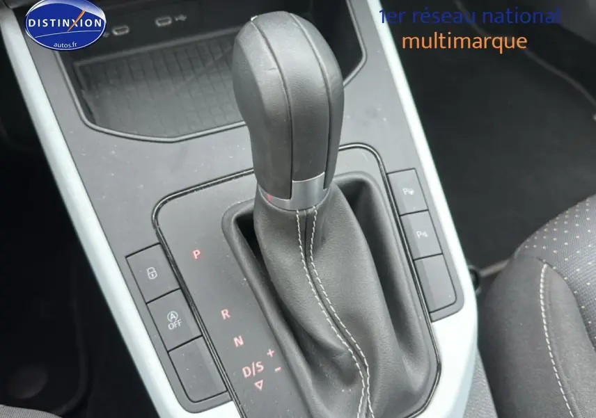 Gros plan sur le levier de vitesse automatique en cuir noir avec coutures blanches, console centrale du SEAT Arona 2025.