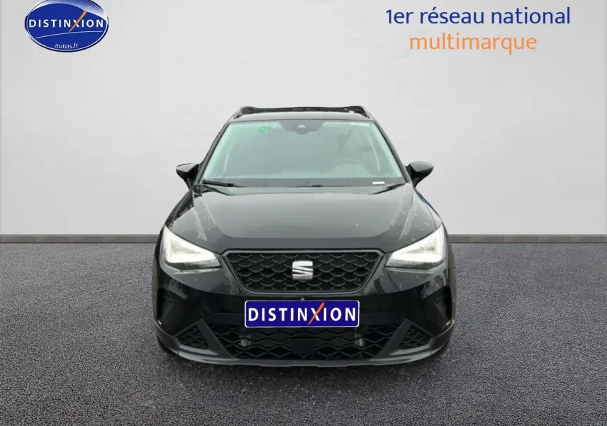 Vue frontale d'un SEAT Arona noir minuit 2025 avec calandre hexagonale et phares LED allumés.