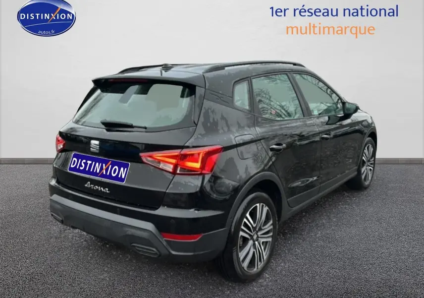 Vue 3/4 arrière droite d'un SEAT Arona noir minuit avec jantes 17 pouces et signature manuscrite sur hayon.