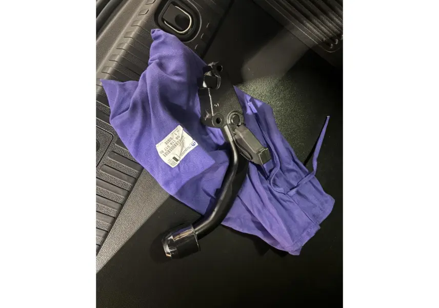 Détail de l'attelage col de cygne démontable posé sur le sol noir du coffre du FIAT Scudo Fourgon gris foncé.