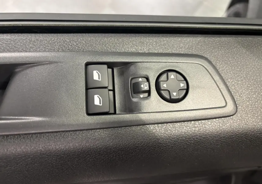 Vue rapprochée des commandes de lève-vitres et réglage des rétroviseurs sur la porte intérieure noire du Fiat Scudo Fourgon gris foncé.