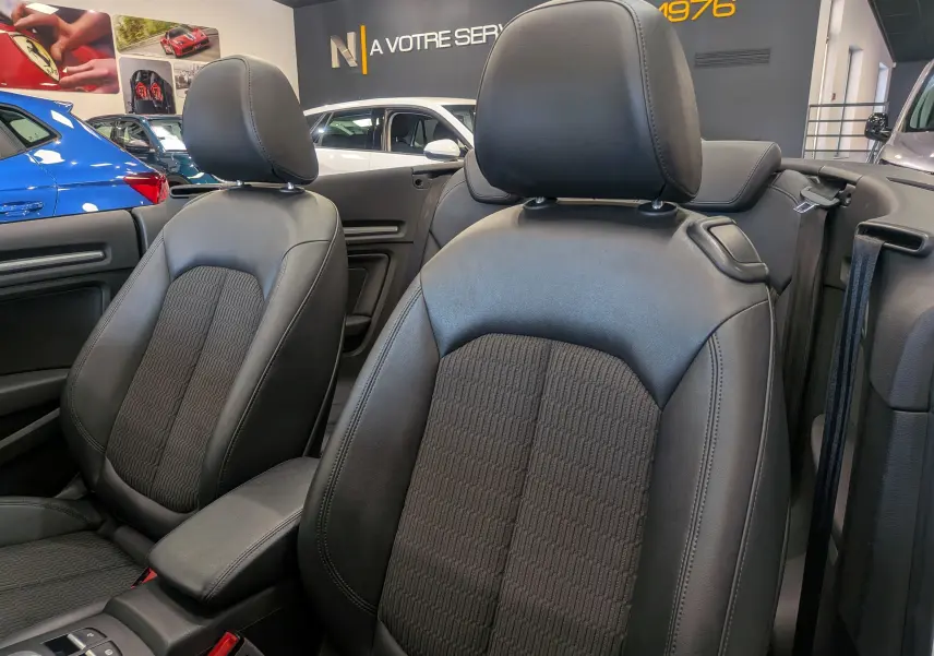 Gros plan sur les sièges avant en cuir noir de l'Audi A3 Cabriolet blanc, intérieur ouvert et moderne en concession.