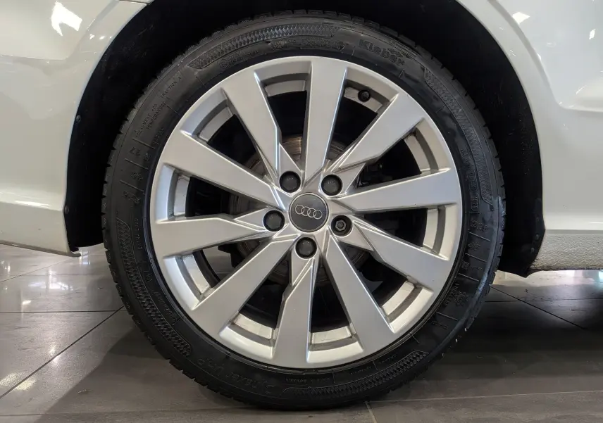 Gros plan sur la roue avant droite d'une Audi A3 Cabriolet blanche de 2017, mettant en valeur la jante en alliage argentée.