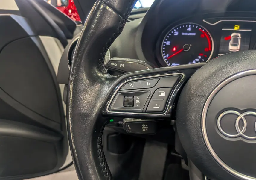 Gros plan sur le volant en cuir noir côté gauche de l'Audi A3 Cabriolet 2017 avec tableau de bord et commandes visibles.